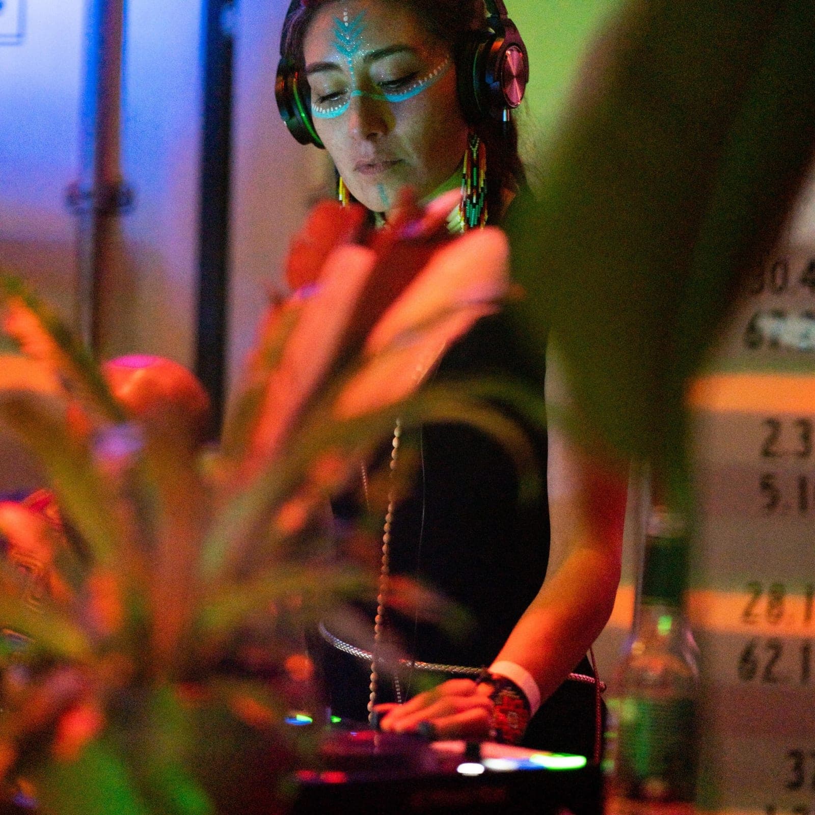DJ XHIVA at the decks, wearing headphones
