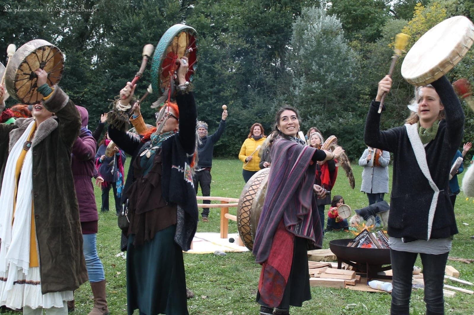 Musicians with frame drums and rattles at an outdoor gathering