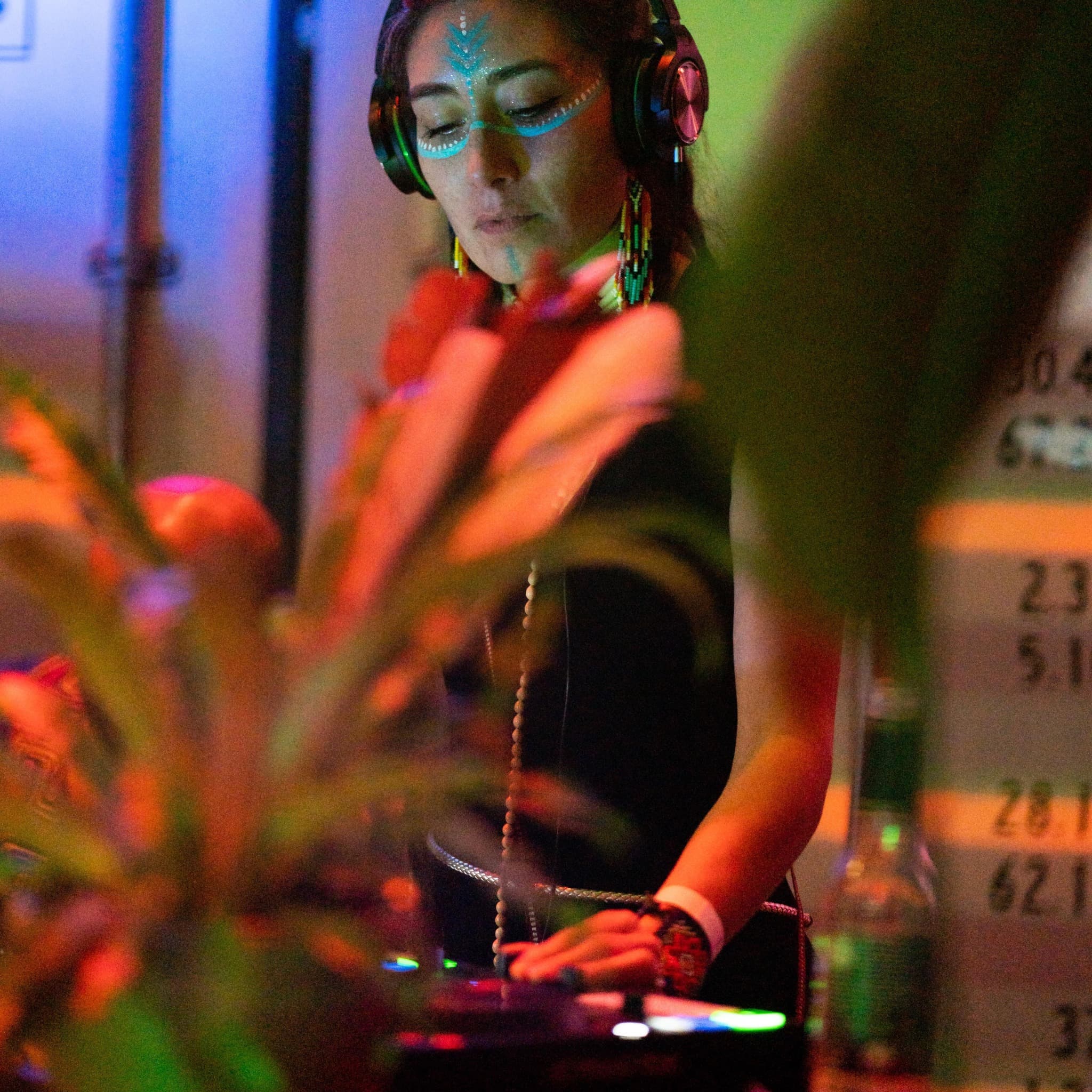 XHIVA playing a DJ set, wearing headphones
